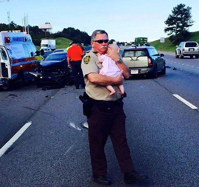  EMOŢIONANT: Un agent de poliţie calmează un bebeluş după accident