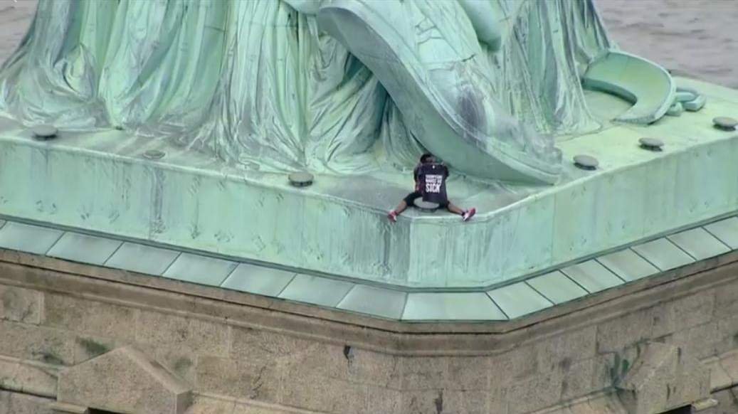  (VIDEO) O femeie s-a căţărat pe Statuia Libertăţii de Ziua Independenţei în semn de protest