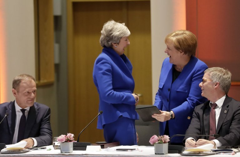  May şi Merkel râd, la începutul summitului UE, privind la tableta cancelarului