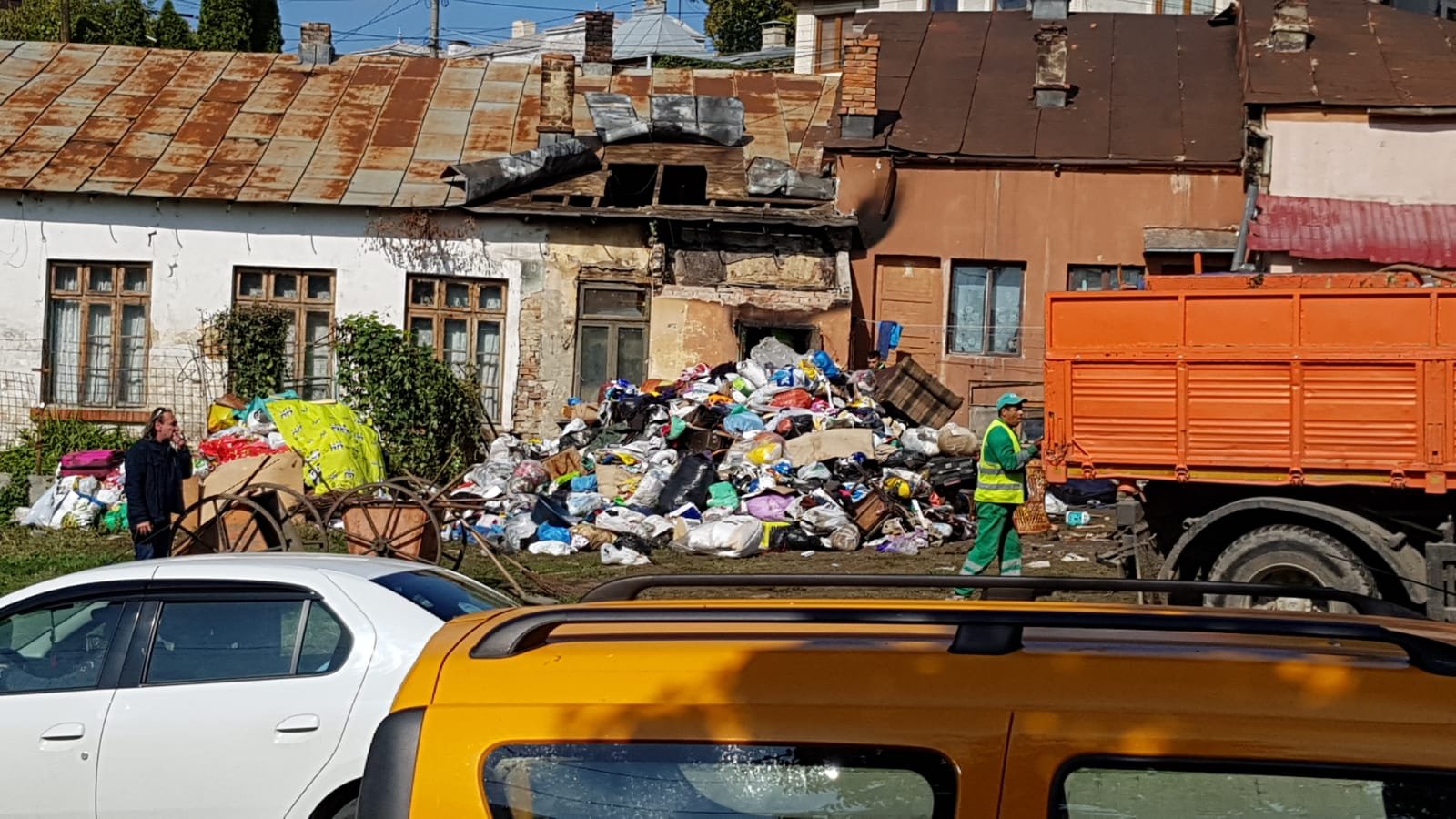  FOTO: Munți de gunoaie în casa unor romi din Păcurari. Muncitorii încarcă camioane