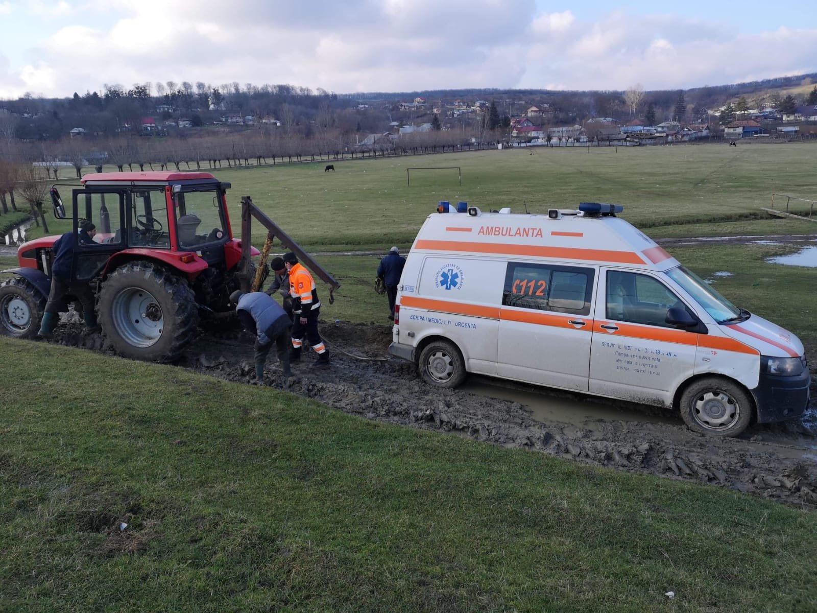  România, Vaslui: Ambulanță blocată în noroi, scoasă cu tractorul