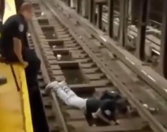  (VIDEO) Momentul în care un polițist și un bun samaritean salvează un bărbat căzut pe șinele de la metroul din New York