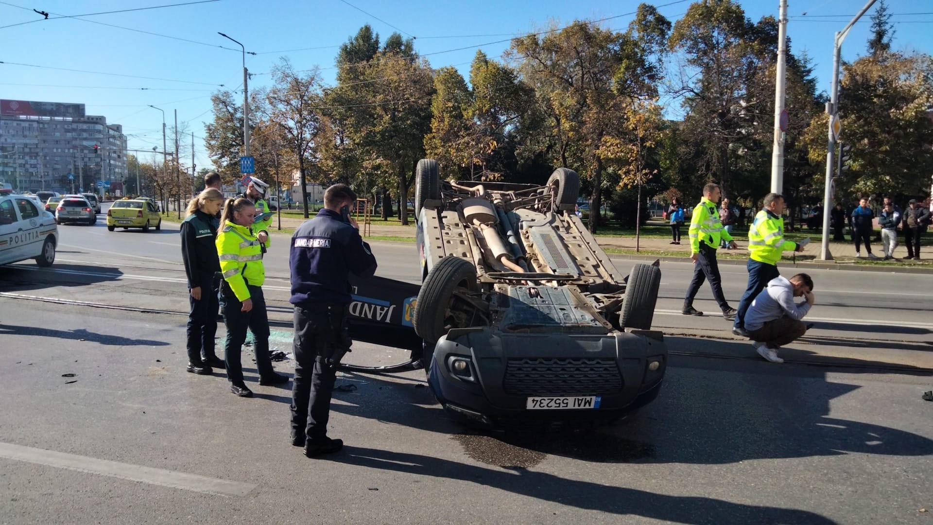  O maşină a Jandarmiei s-a răsturnat în urma unui accident în faţa BCR din Podu Roş