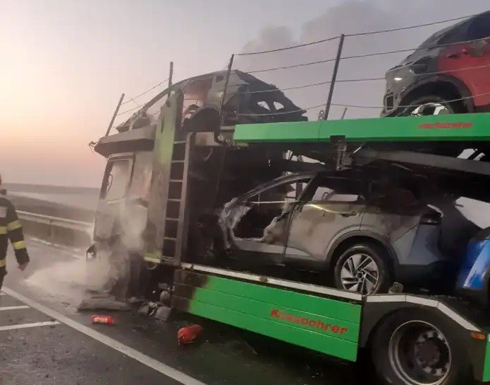  VIDEO: O platformă care transporta opt autoturisme a luat foc în trafic. Patru maşini au fost incendiate